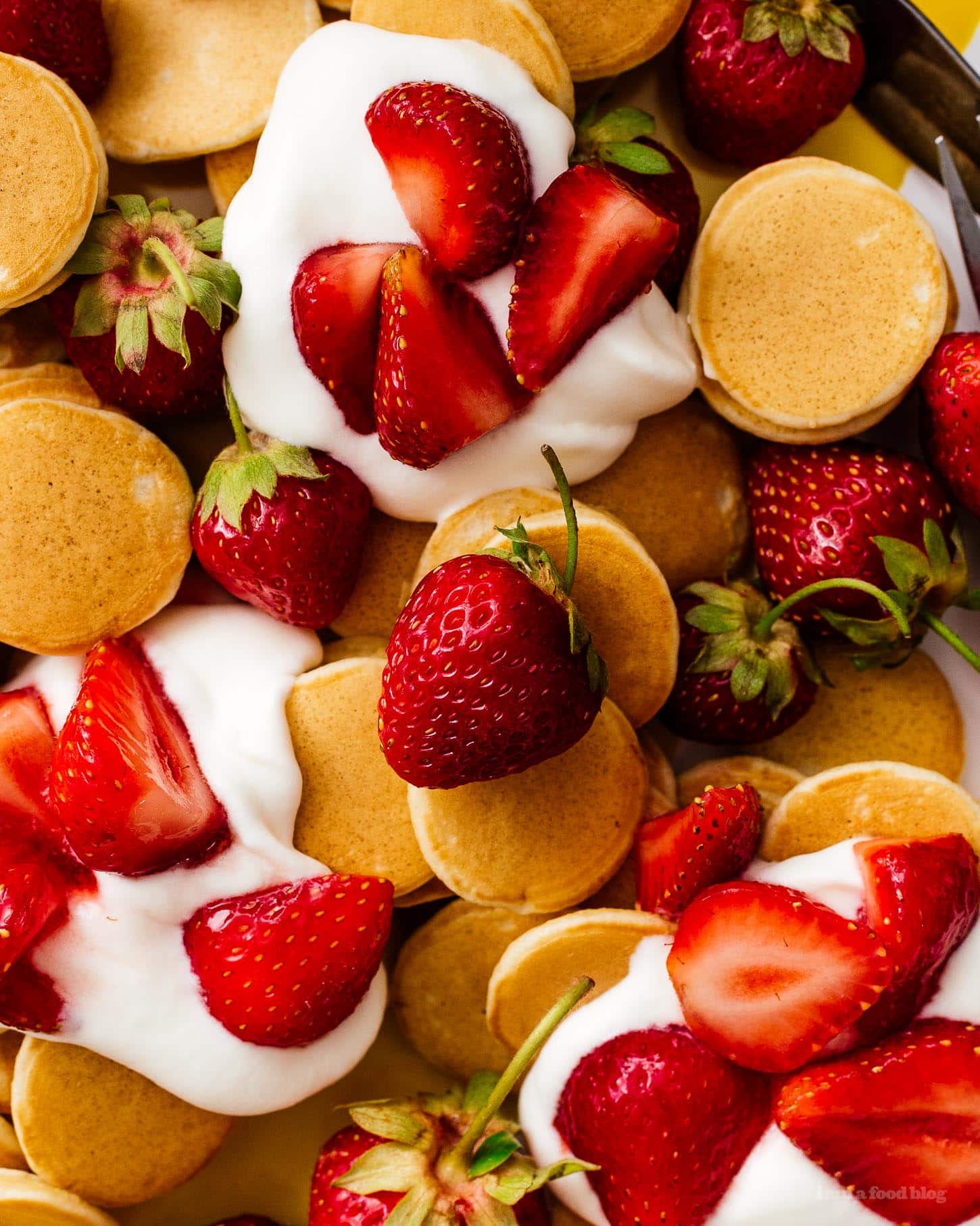 This fluffy mini strawberry shortcake pancake recipe is perfect for summer. Super cute mini silver dollar vanilla pancakes topped with juicy strawberries and softly whipped cream. Like a strawberry shortcake for breakfast! #strawberries #strawberry #strawberrypancakes #strawberrypancake #strawberryshortcake #strawberryshortcakes
