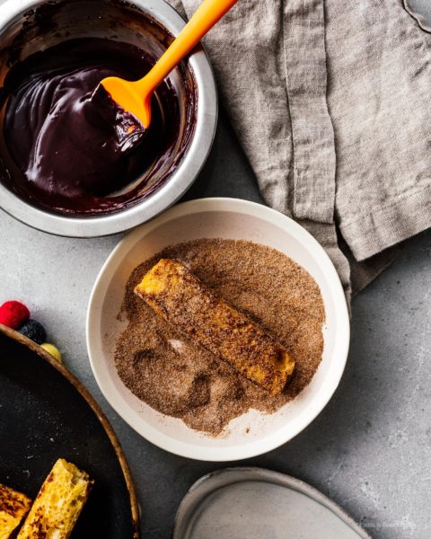 This is going to be the best French toast you’ll ever eat! Cure your churro and French toast cravings with these golden brown crispy French toast sticks dipped in cinnamon and sugar. Dark chocolate dipping sauce not optional! #breakfast #brunch #recipes #frenchtoast #churros #cinnamonsugar #frenchtoaststicks