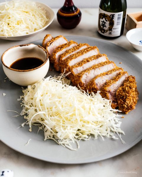 Easy oven baked pork tonkatsu: An extra thick, super juicy pork chop done up tonkatsu style, with light and crispy panko, only baked instead of deep-fried. #japanesefood #japanese #tonkatsu #porkchop #pork #recipes #ovenbaked #dinner #easydinner